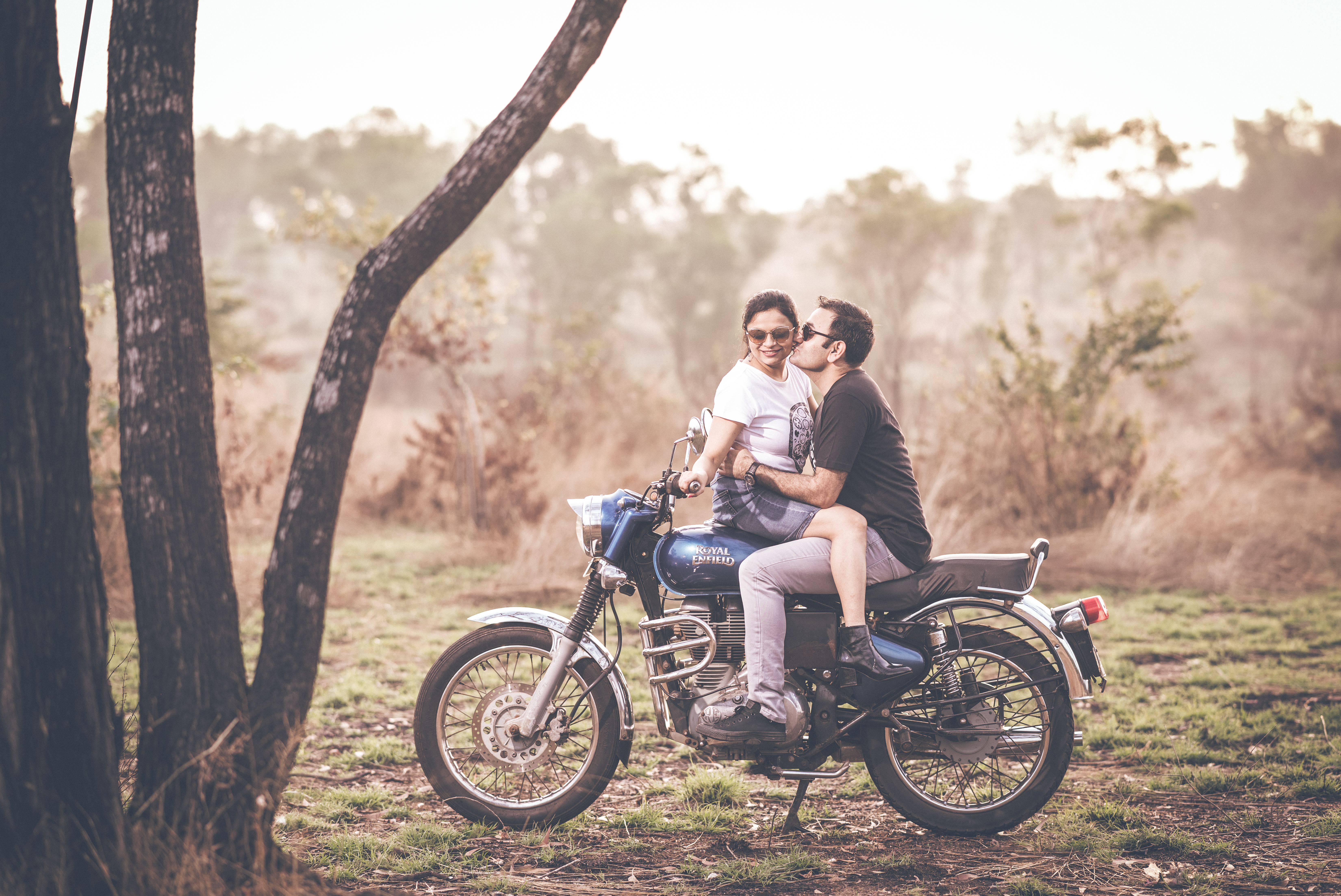 Couple laughing together in a garden during pre-wedding shoot