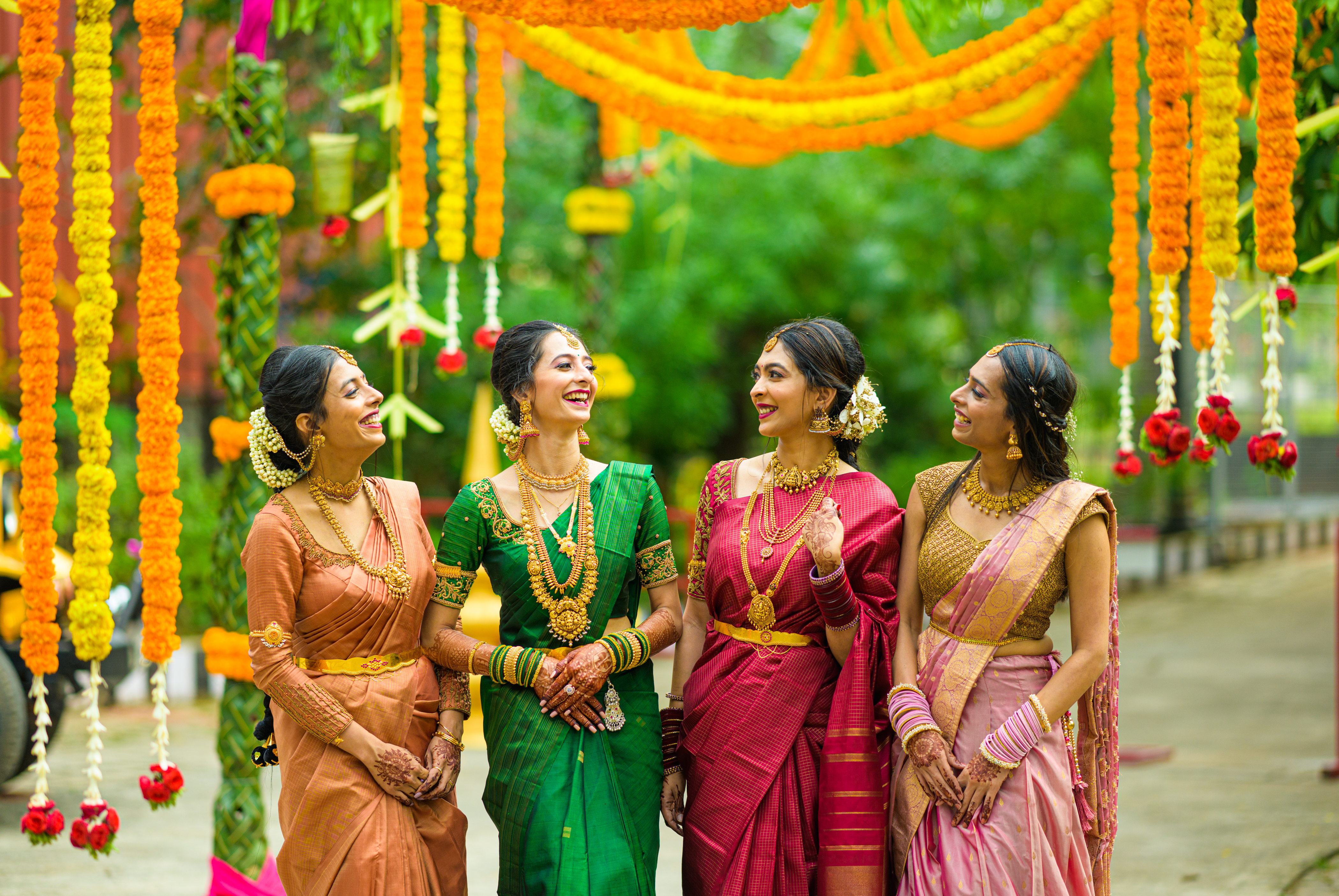 A candid shot of the bride laughing with her bridesmaids amidst colorful wedding decor