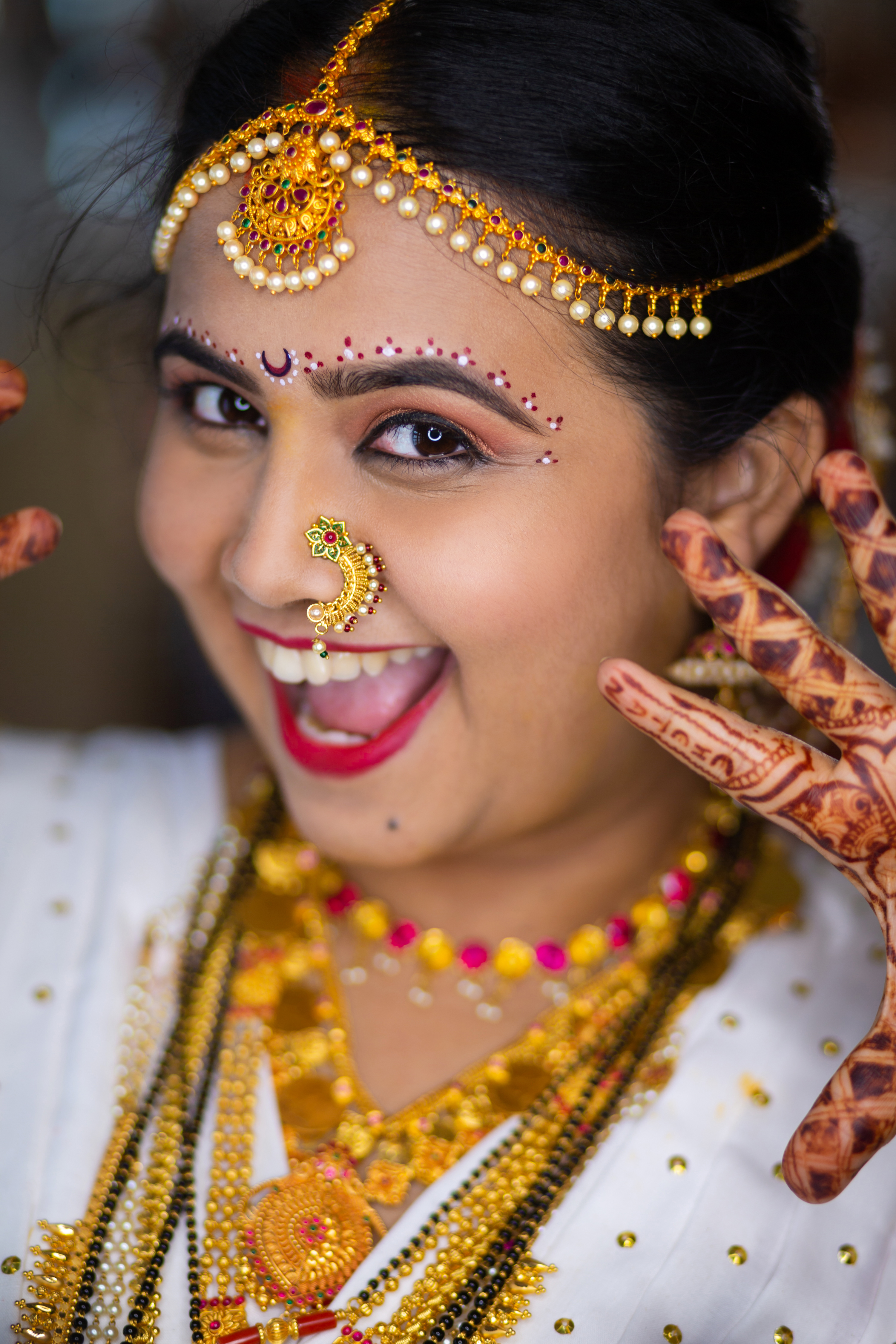 Close-up of hands with intricate henna designs holding a decorative diya