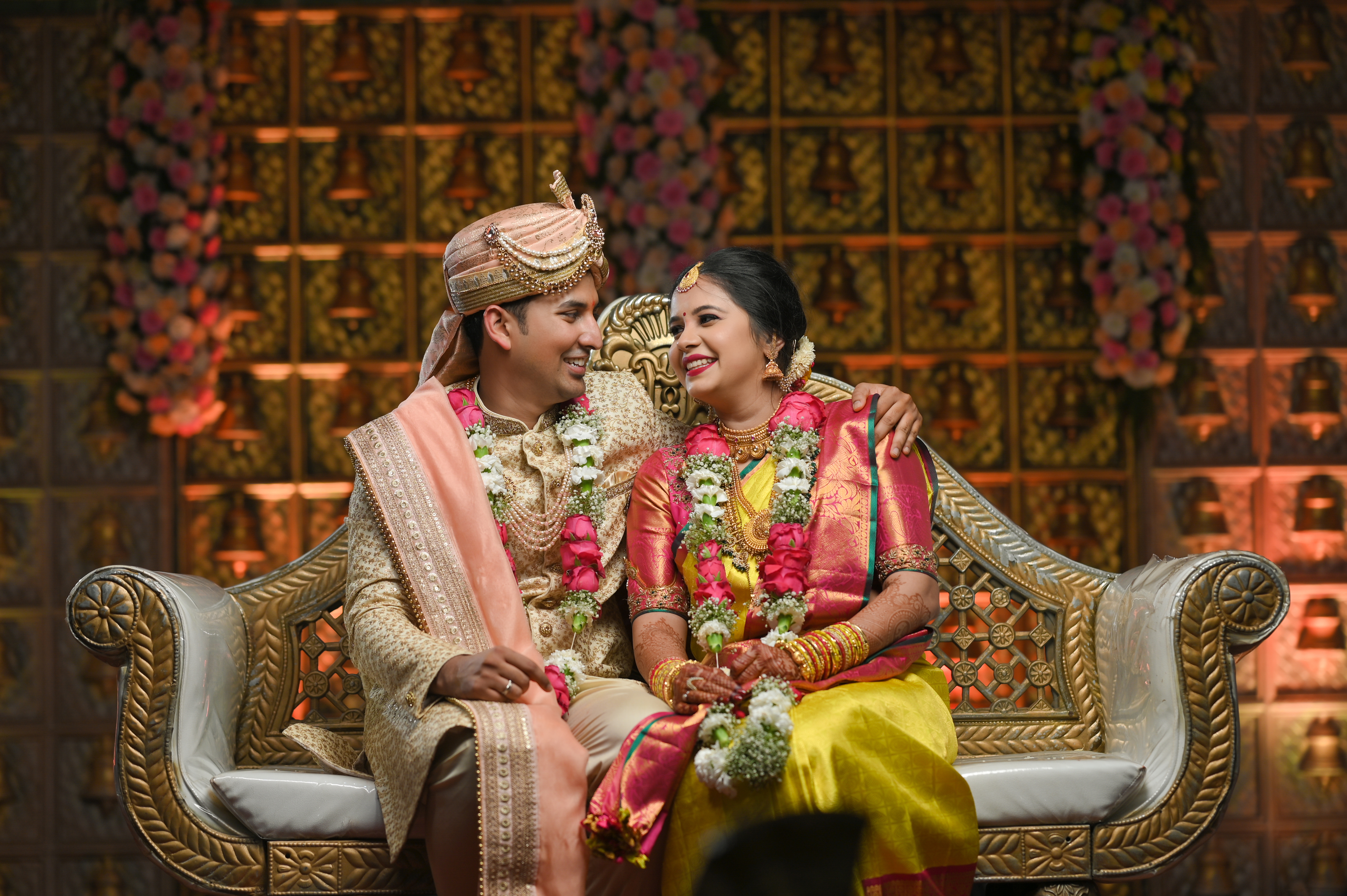 Beautifully adorned wedding venue at dusk with glowing string lights and floral arrangements