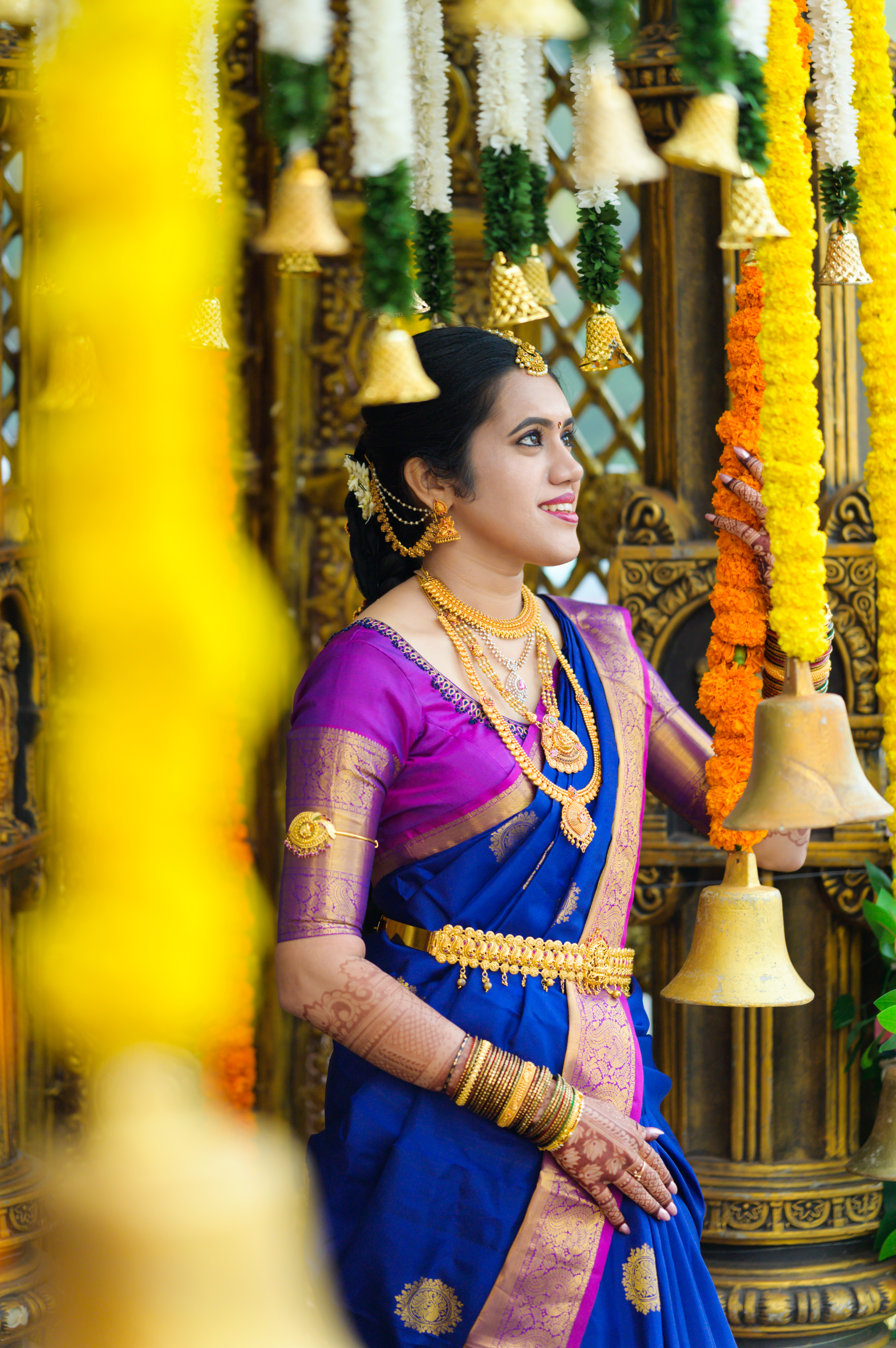 Bride and groom exchanging vows under a beautifully decorated mandap with traditional flowers and lights