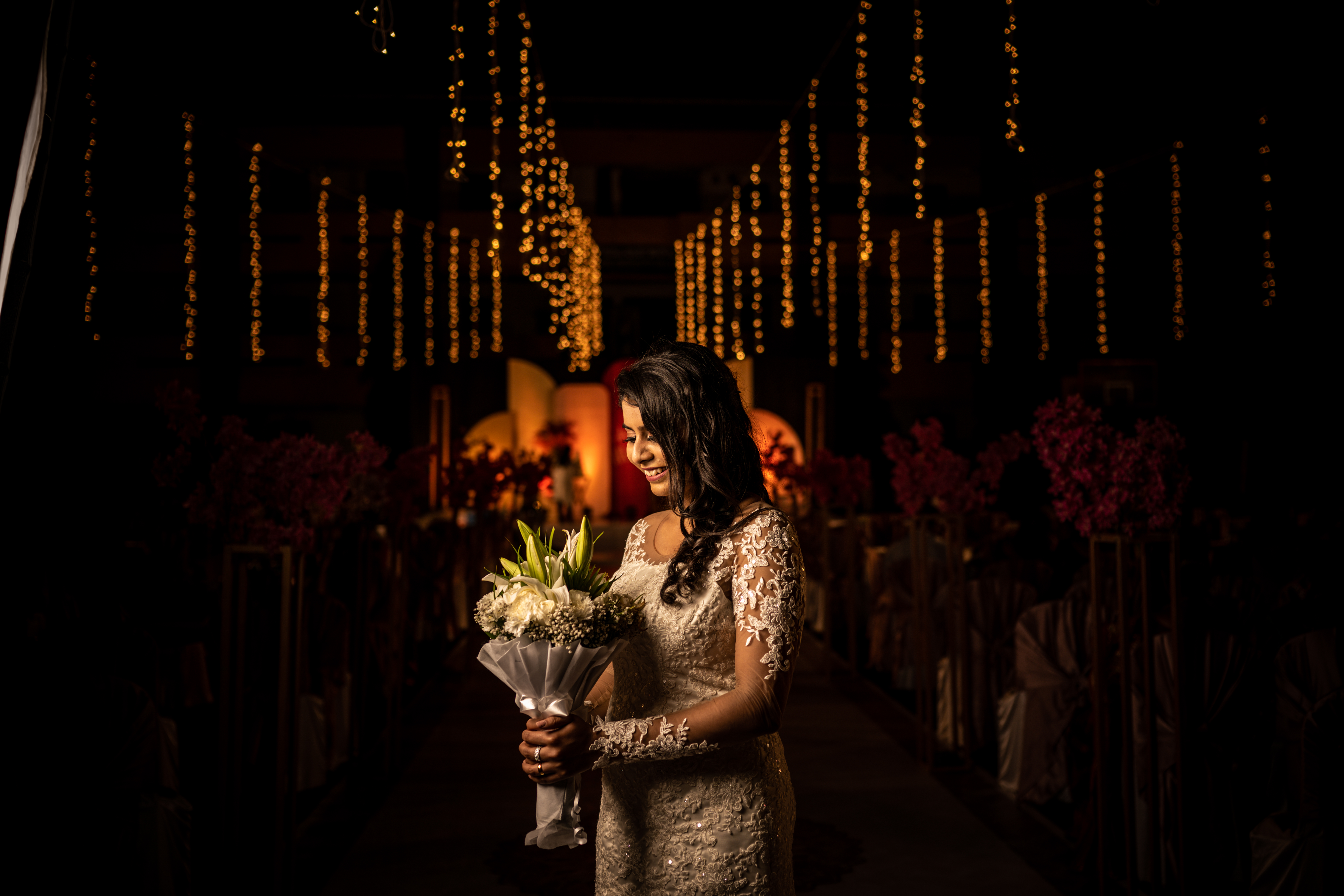 Bride and groom exchanging vows under a beautifully decorated mandap with traditional flowers and lights