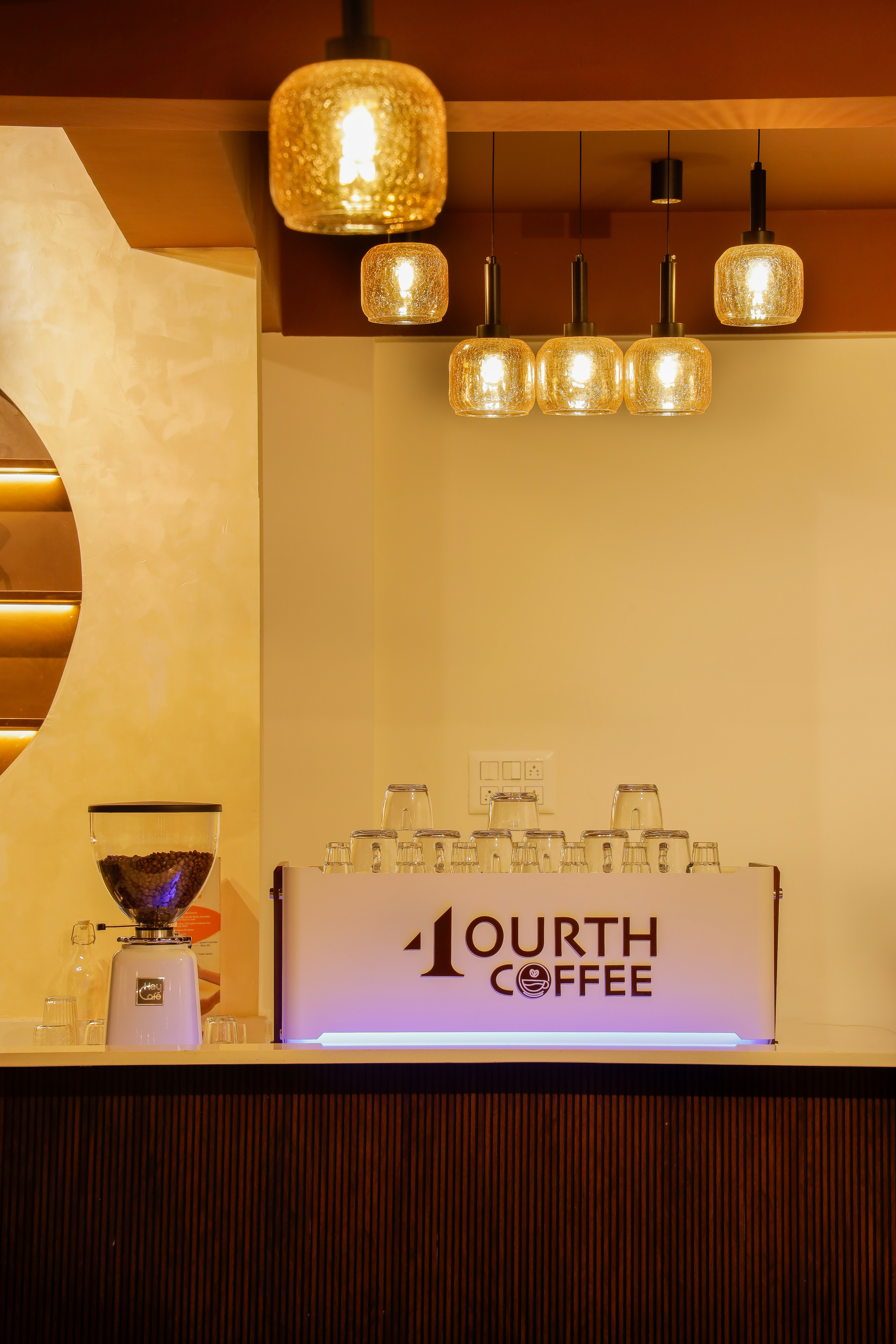 Bengaluru specialty café with barista pulling espresso shots beside trays of protein bakes, warm industrial interiors, and corporate teams picking up coffee for meetings